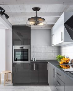 a modern kitchen with stainless steel appliances and fruit on the counter