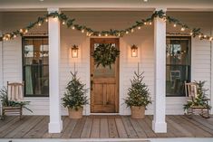 front porch decorated for christmas with wreaths and lights