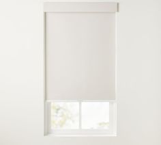 a white roller shade in a bedroom window