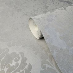 a close up view of a wallpaper with grey and white floral designs on it