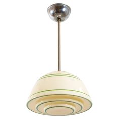 a white and green pendant light hanging from a ceiling fixture with a metal ball at the top