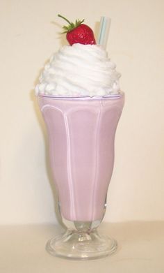 a glass filled with whipped cream and a strawberry on top