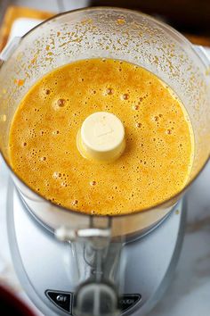 a blender filled with yellow liquid on top of a counter