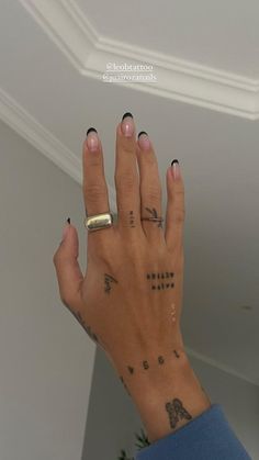 a woman's hand with tattoos on it