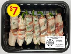 several pieces of meat wrapped in bacon and green peppers on a black tray with the price $ 7 99