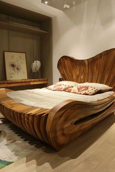 a wooden bed sitting on top of a hard wood floor next to a white wall