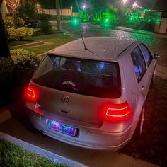 a car is parked on the side of the road at night with its lights on