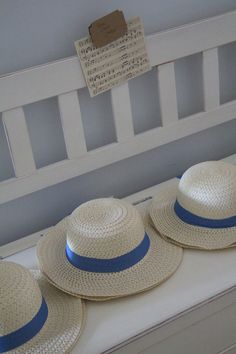 three hats sitting on top of a white bench