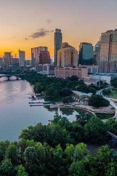 an aerial view of the city and river at sunset