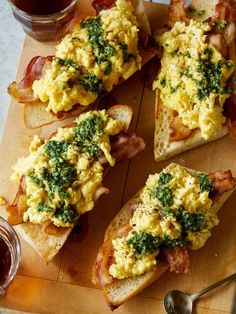 several pieces of bread with eggs and spinach on them sitting on a cutting board