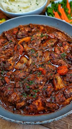 meat and vegetable stew in a pan with mashed potatoes