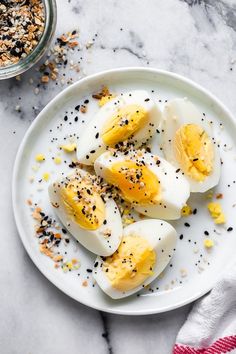 an image of boiled eggs with chives and seasoning on a plate next to a bowl