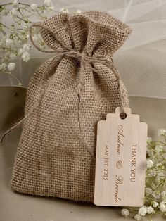 a small bag with a tag on it next to some baby's breath flowers