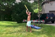 a shirtless man holding a baseball bat over his head