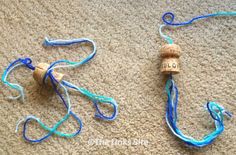 two pieces of blue string tied together on the floor next to an empty bottle opener