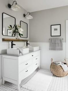 a white bathroom with two sinks and mirrors