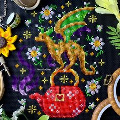 the cross stitch pattern is on display with scissors and other crafting supplies