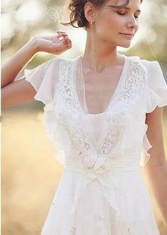 a woman wearing a white wedding dress in the sun