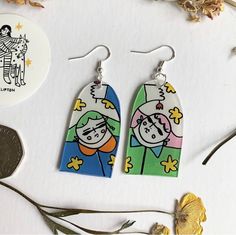 the earrings are made out of polymer and have cartoon characters on them, along with a penny