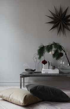 a table with two pillows on top of it and a star shaped clock above it