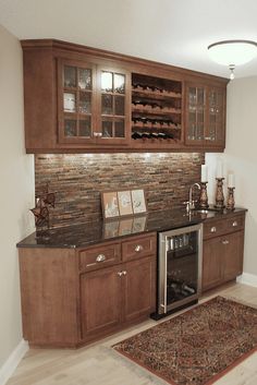 a kitchen with wooden cabinets and granite counter tops, along with a rug on the floor