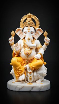 an elephant statue sitting on top of a white marble base with gold trimmings