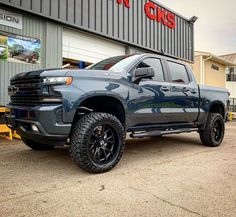 a blue truck parked in front of a building