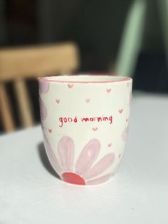 a coffee cup sitting on top of a white table