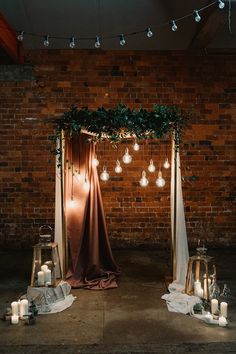 an image of a wedding arch decorated with lights and greenery on the wall behind it