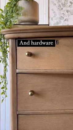 there is a plant on top of a dresser with the words and hardware above it