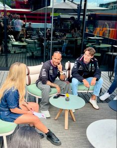 three people sitting on chairs talking to each other