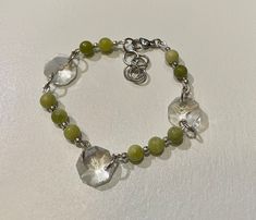 This bracelet has been made using 8mm Jade Beads , silver tone, metallic, spacer beads and octagonal crystal ( chandelier drops), which have been wired with silver plated wire and stainless steel jump rings. The bracelet fastens with a lobster claw clasp and has a small extension chain. The bracelet is adjustable and suitable for a wrist from 17cm to 21cm Small Extension, Crystal Beads Bracelet, Jade Bracelet, Jade Beads, Jump Rings, Crystal Chandelier, Spacer Beads, Lobster Claw, Beaded Bracelet