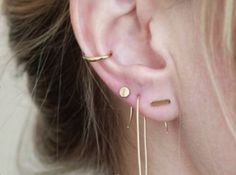 a woman wearing ear piercings in gold