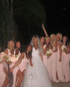 the bride and her bridal party are posing for a photo in front of palm trees