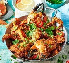 a bowl filled with cooked crabs and garnished with cilantro