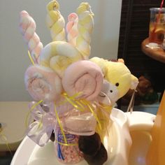 a teddy bear sitting on top of a cup filled with candy and marshmallows