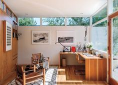 a living room filled with lots of furniture next to a wall covered in pictures and windows