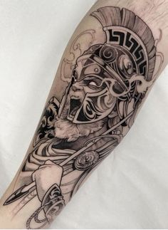 a man's arm with an egyptian mask and dagger tattoo on the left forearm