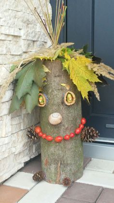 a tree stump with a planter made to look like a face on the front door