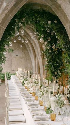 a long table is set with white flowers and candles