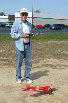 a man standing next to a remote control plane