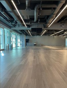 an empty room with wooden floors and large windows