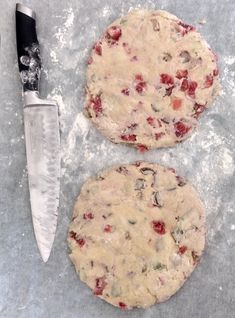 an uncooked pizza sitting on top of a table next to a knife