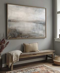 a large painting hanging on the wall above a wooden bench in front of a window