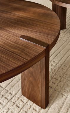 a close up of a wooden table on a carpeted floor with white rugs