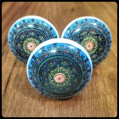 three blue and green plates sitting on top of a wooden table next to each other