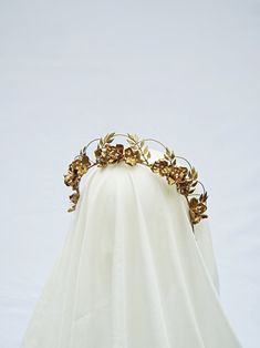 This vintage-inspired crown is crafted for the contemporary bride, making it a captivating choice for weddings, events, anniversaries, and various special occasions. Notable Features: Delicately handmade wired leaves and hand sculpted clay flowers adorned with intricate beaded accents. Enveloped in a lustrous gold metallic finish. Designed to be exceptionally lightweight, ensuring comfort throughout the day. Approximate Dimensions: * Wire band length: 14 inches * Tallest point when worn: 1.5 inc Magpie Hoard, Floral Bridal Crown, Gold Flower Crown, Gala Party, Bride Crown, Contemporary Bride, Clay Flower, Sculpting Clay, Bridal Crown