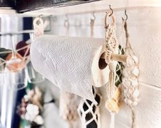 there are many items hanging from the hooks on the wall and in the holder is a roll of rope