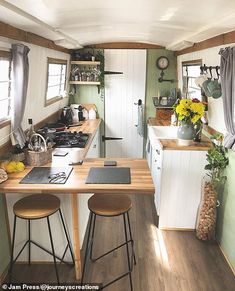 a kitchen with wooden floors and white cabinets in a tiny house on wheels that has been converted into a mobile home