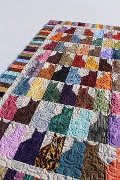 a multicolored quilt with cats on it